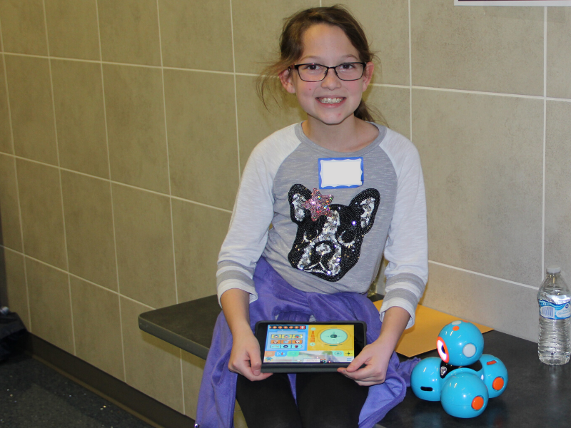 Student smiles and sits on a table